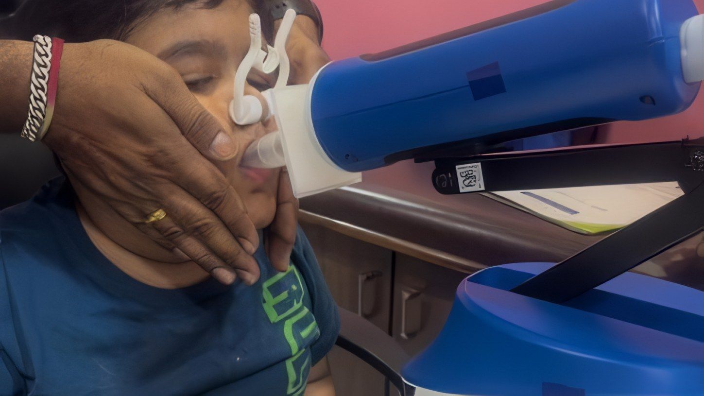 A child breathes into the FOT lung function machine